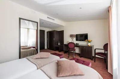 a hotel room with two beds and a television at Amberton Cathedral Square Hotel Vilnius in Vilnius