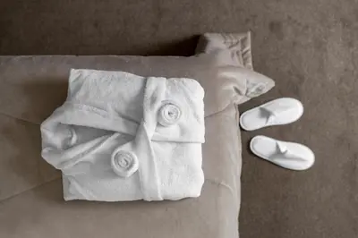 a bed with white towels and a pair of slippers at Amberton Cathedral Square Hotel Vilnius in Vilnius