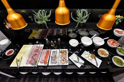 a table with plates of food on a table at Amberton Cathedral Square Hotel Vilnius in Vilnius