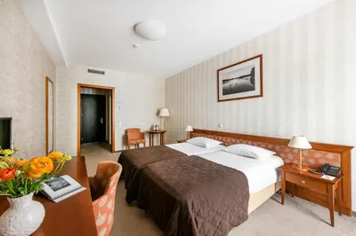 a hotel room with a bed and a table at Amberton Cathedral Square Hotel Vilnius in Vilnius