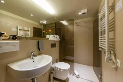 a bathroom with a sink and a toilet and a shower at Amberton Cathedral Square Hotel Vilnius in Vilnius