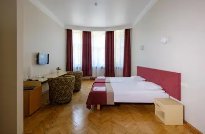 a hotel room with a bed and a desk at Hotel Metropolis in Kaunas