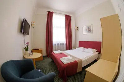 a hotel room with a bed and a chair at Hotel Metropolis in Kaunas