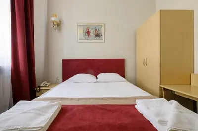 a bedroom with a large bed with a red headboard at Hotel Metropolis in Kaunas