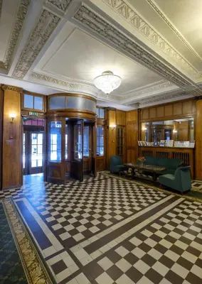 a large room with a checkered floor and a ceiling at Hotel Metropolis in Kaunas