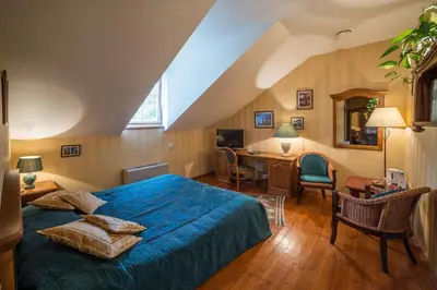 a bedroom with a blue bed and a desk with a computer at Shakespeare Boutique Hotel in Vilnius