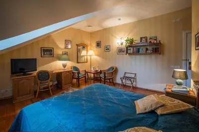 a bedroom with a blue bed and a table and chairs at Shakespeare Boutique Hotel in Vilnius