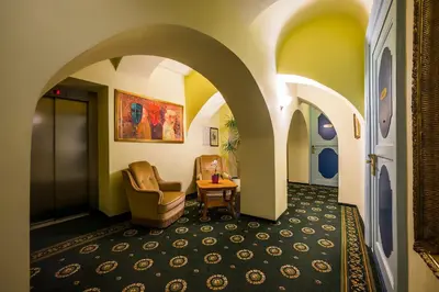a hallway with arches and a chair and a table at Shakespeare Boutique Hotel in Vilnius