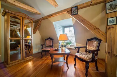 a living room with a table and chairs and a mirror at Shakespeare Boutique Hotel in Vilnius
