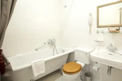 a bathroom with a tub and a toilet and a sink at Shakespeare Boutique Hotel in Vilnius