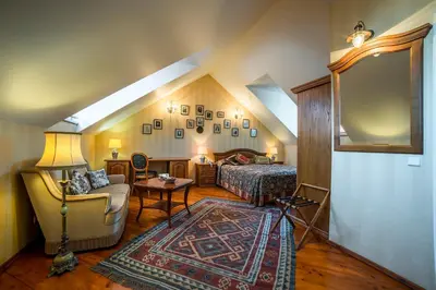 a bedroom with a bed and a couch and a chair at Shakespeare Boutique Hotel in Vilnius