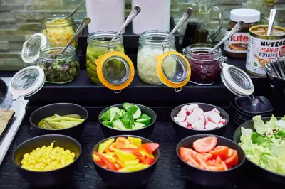 a table topped with bowls of different types of food at Holiday Inn Vilnius by IHG in Vilnius