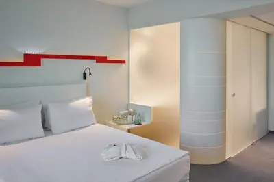 a bedroom with a white bed with a towel on it at Holiday Inn Vilnius by IHG in Vilnius