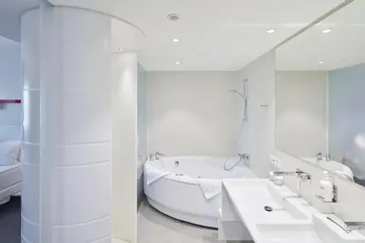 a white bathroom with two sinks and a tub at Holiday Inn Vilnius by IHG in Vilnius
