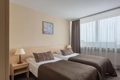 a hotel room with two beds and a window at Hotel Panorama in Vilnius
