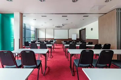 a conference room with tables and chairs and a whiteboard at Hotel Panorama in Vilnius
