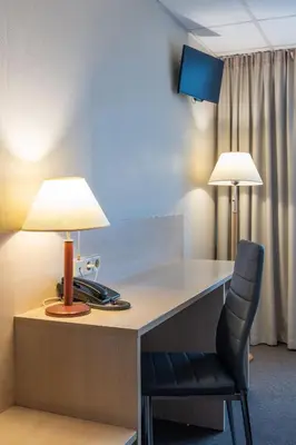 a desk with a lamp and a chair at Hotel Panorama in Vilnius