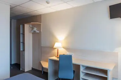 a room with a desk and a blue chair at Hotel Panorama in Vilnius