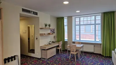 a hair salon with green curtains and a table and chairs at City Hotels Rūdninkai in Vilnius