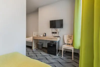 a room with a desk with a computer and a tv at City Hotels Rūdninkai in Vilnius