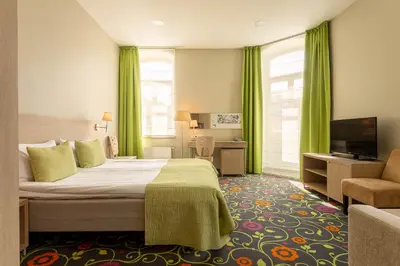 a hotel room with a bed and a television at City Hotels Rūdninkai in Vilnius