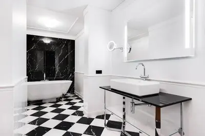 a white bathroom with a black and white checkered floor at Grotthuss Boutique Hotel Vilnius in Vilnius