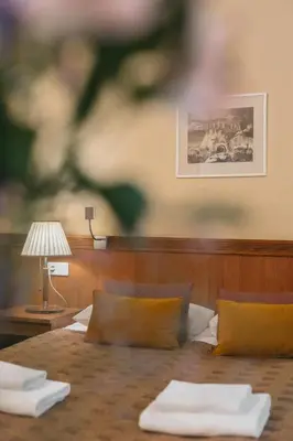 a room with a bed with a table and a lamp at Hotel Rinno in Vilnius