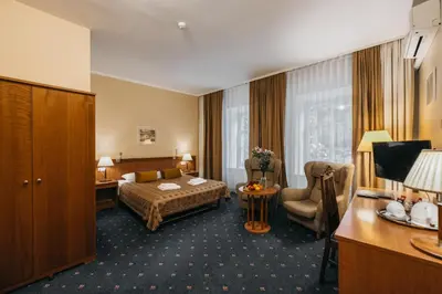 a hotel room with a bed and a chair at Hotel Rinno in Vilnius