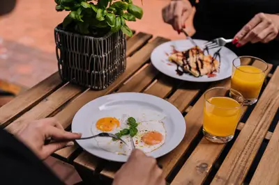 a table with two plates of eggs and two glasses of orange juice at Hotel Rinno in Vilnius