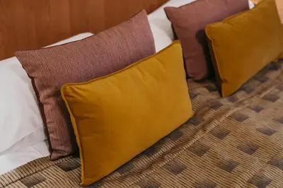 three pillows sitting on top of a bed at Hotel Rinno in Vilnius