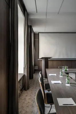a conference room with a table and chairs and a screen at Congress Hotel in Vilnius