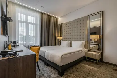 a hotel room with a bed and a desk at Congress Hotel in Vilnius
