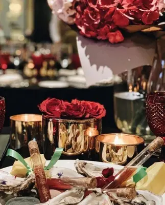 a table topped with a plate with flowers and candles at NARUTIS Hotel - Small Luxury Hotels of The World in Vilnius