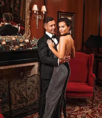 a man and a woman standing next to a fireplace at NARUTIS Hotel - Small Luxury Hotels of The World in Vilnius