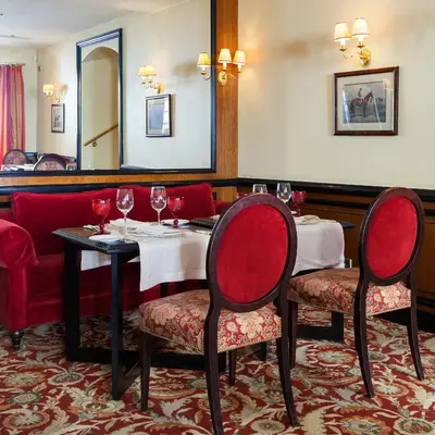 a restaurant with two tables and chairs with wine glasses at NARUTIS Hotel - Small Luxury Hotels of The World in Vilnius