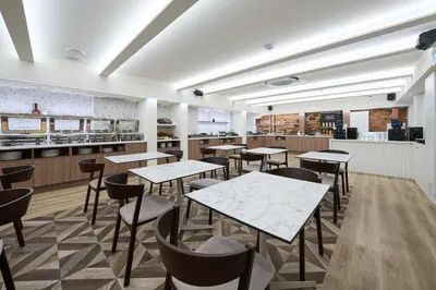 a restaurant with tables and chairs and a kitchen at Kaunas in Kaunas