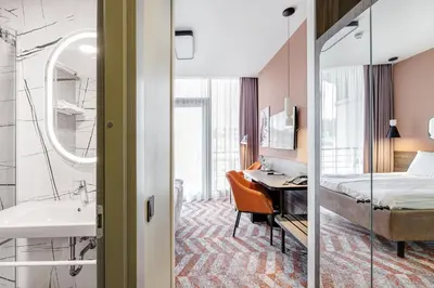 a hotel room with a desk and a bed and a sink at Kaunas in Kaunas