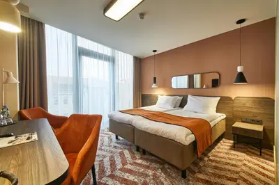 a hotel room with a bed and a desk at Kaunas in Kaunas
