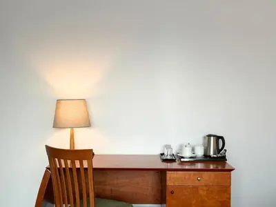 a wooden desk with a lamp and a chair at BEST BALTIC Kaunas in Kaunas