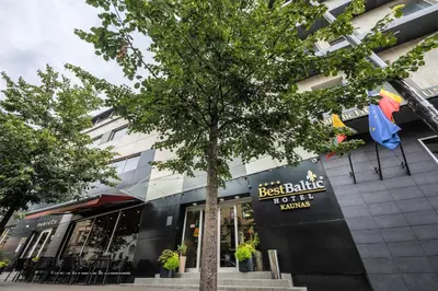 a tree in front of a building with a store at BEST BALTIC Kaunas in Kaunas