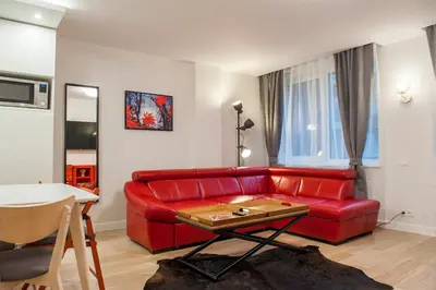 a living room with a red couch and a table at Natalex Apartments in Vilnius