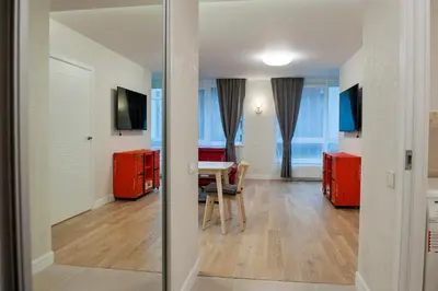 a living room with a table and red cabinets at Natalex Apartments in Vilnius