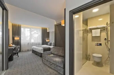 a hotel room with a couch and a bed at Congress Avenue Hotel in Vilnius