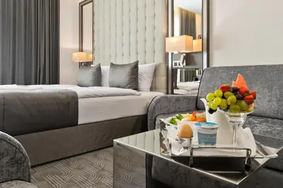a hotel room with a bed and a table with fruit on it at Congress Avenue Hotel in Vilnius