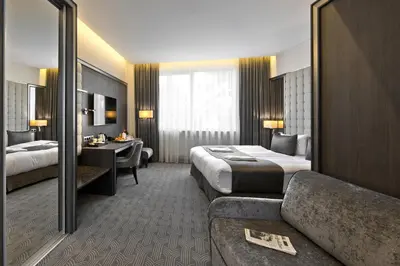 a hotel room with two beds and a couch at Congress Avenue Hotel in Vilnius