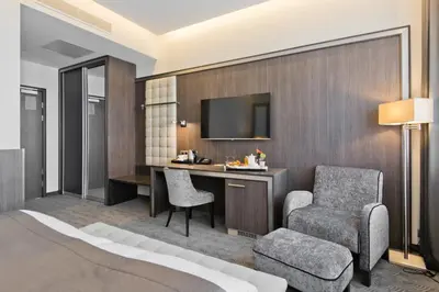 a bedroom with a bed and a desk and a chair at Congress Avenue Hotel in Vilnius