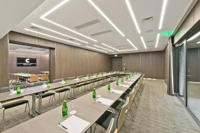 a conference room with long tables and chairs at Congress Avenue Hotel in Vilnius