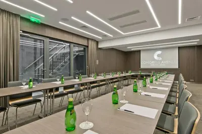 a conference room with long tables and green bottles at Congress Avenue Hotel in Vilnius