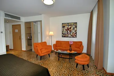a hotel room with orange chairs and a bed and a table at City Gate in Vilnius