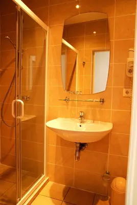 a bathroom with a sink and a shower with a mirror at City Gate in Vilnius